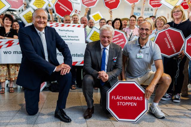 25 June 2026, Baden-Wuerttemberg, Freiburg: Alois Rainer (C), Germany's Agriculture Minister; Joachim Rukwied (L), President of the German Farmers' Association; and Ely Eibisch of the Bavarian Farmers' Association pose with demonstrators at the Freiburg Trade Fair. Photo: Philipp von Ditfurth/dpa