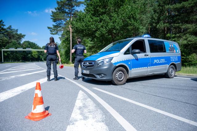 25 June 2026, Mecklenburg-Western Pomerania, Neustrelitz: Police officers stand on Federal Highway B193 north of Neustrelitz. According to police, the road remains completely closed in the area. Photo: Stefan Sauer/dpa