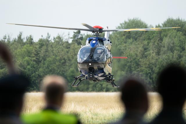 25 June 2026, Saxony, Dresden: Attendees at the commissioning ceremony watch as a new Airbus H145 police helicopter lands at Dresden Airport. The new helicopters are more powerful and larger than their predecessors. Photo: Sebastian Kahnert/dpa