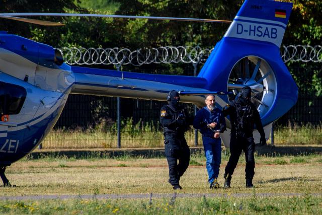 26 June 2026, Saxony-Anhalt, Magdeburg: Court officers lead the defendant, Taleb al-Abdulmohsen, into the courtroom. On December 20, 2024, the defendant drove a rental car through the crowded Christmas market. As a result of the attack, which lasted just over a minute, five women and a nine-year-old boy were killed, and hundreds of people were injured. Photo: Klaus-Dietmar Gabbert/dpa
