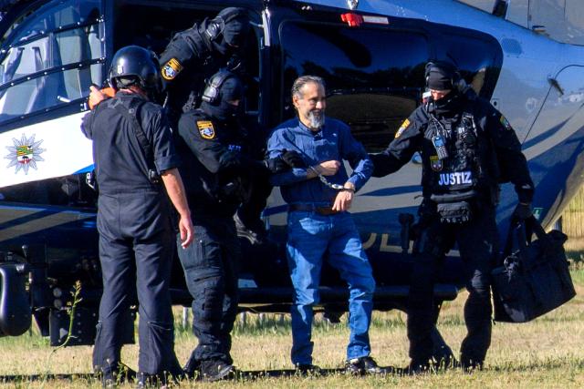 26 June 2026, Saxony-Anhalt, Magdeburg: Court officers lead the defendant, Taleb al-Abdulmohsen, into the courtroom. On December 20, 2024, the defendant drove a rental car through the crowded Christmas market. As a result of the attack, which lasted just over a minute, five women and a nine-year-old boy were killed, and hundreds of people were injured. Photo: Klaus-Dietmar Gabbert/dpa