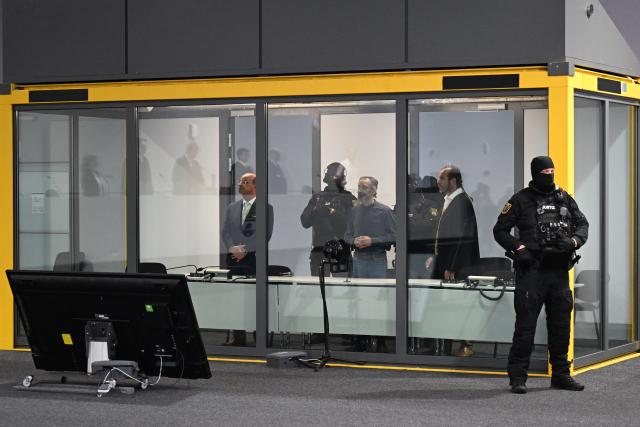 26 June 2026, Saxony-Anhalt, Magdeburg: Court officers lead the defendant, Taleb al-Abdulmohsen, into the courtroom and into the security booth. On December 20, 2024, the defendant drove a rental car through the crowded Christmas market. As a result of the attack, which lasted just over a minute, five women and a nine-year-old boy were killed, and hundreds of people were injured. Photo: Hendrik Schmidt/dpa