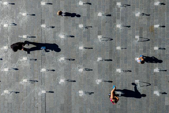 26 June 2026, North Rhine-Westphalia, Duisburg: Children play in the water jets of a walk-through fountain in the city center amid midsummer temperatures. Photo: Christoph Reichwein/dpa