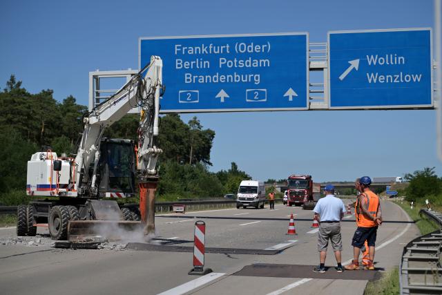 26 June 2026, Brandenburg, Wollin: An excavator fitted with a jackhammer works on a damaged section of concrete roadway near the Wollin exit on the A2 highway toward Berlin, where sections of the road shifted against one another due to pressure caused by high temperatures during the current heat wave. Photo: Michael Bahlo/dpa