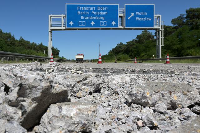 26 June 2026, Brandenburg, Wollin: Broken chunks of concrete lie beside the road after sections of the concrete roadway near the Wollin exit on the A2 highway toward Berlin shifted against one another due to pressure caused by high temperatures during the current heat wave. Photo: Michael Bahlo/dpa