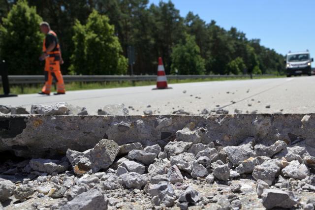 26 June 2026, Brandenburg, Wollin: Broken chunks of concrete lie beside the road after sections of the concrete roadway near the Wollin exit on the A2 highway toward Berlin shifted against one another due to pressure caused by high temperatures during the current heat wave. Photo: Michael Bahlo/dpa