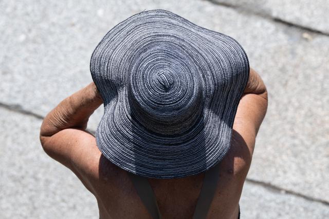 26 June 2026, Saxony, Dresden: A woman wearing a sun hat walks through Dresden's Old Town during a heat wave. Photo: Sebastian Kahnert/dpa