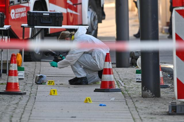 26 June 2026, Saxony-Anhalt, Haldensleben: A forensic investigator examines a crime scene on the edge of the market square as police conduct an operation following an incident in which at least one person was injured, according to the Magdeburg Police Department. Photo: Klaus-Dietmar Gabbert/dpa