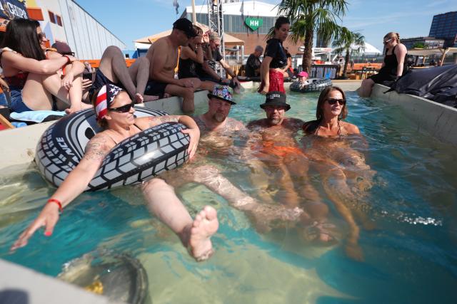 26 June 2026, Hamburg: Visitors cool off in a pool at the Hamburg Wholesale Market during the opening day of Harley Days, Europe's largest inner-city biker gathering. Photo: Marcus Brandt/dpa