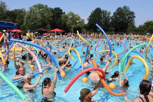27 June 2026, Bremen: People hold pool noodles as they cool off in a swimming pool at Horner Bad in Bremen. Since Saturday afternoon, Bremen has been able to call itself the "pool noodle capital" after the official record for the most people floating with pool noodles at the same time was broken at Horner Bad. Photo: Kai Moorschlatt/dpa
