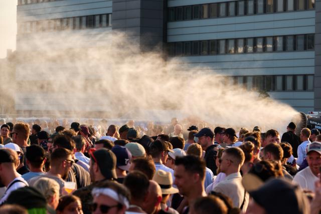 27 June 2026, Hamburg: Fans are sprayed with water from a water cannon to cool them down amid soaring temperatures during a concert by techno star Paul Kalkbrenner on the Heiligengeistfeld in Hamburg. Photo: Marcus Golejewski/dpa