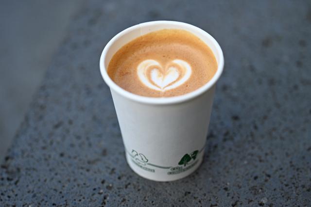 FILED - 23 March 2026, Hesse, Wiesbaden: A flat white with a heart in the milk foam is filled into a cardboard coffee cup. Photo: Michael Brandt/dpa