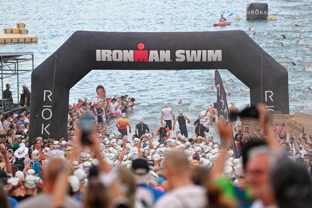 28 June 2026, Hesse, Frankfurt am Main: Competitors head toward the water at the Langener Waldsee, ahead of the swim leg start of the Mainova IRONMAN Frankfurt European Championship. Photo: Uwe Anspach/dpa