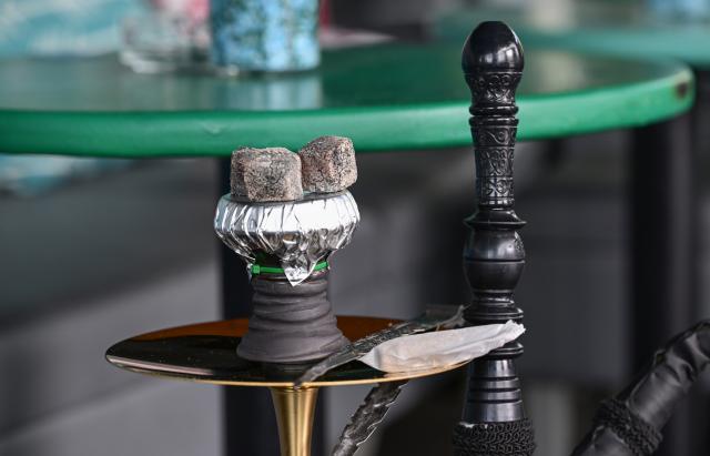FILED - 29 June 2023, Baden-Württemberg, Sindelfingen: File Photo - Pieces of coal for heating the tobacco lie on a hookah water pipe in a hookah bar. Photo: Bernd Weißbrod/dpa