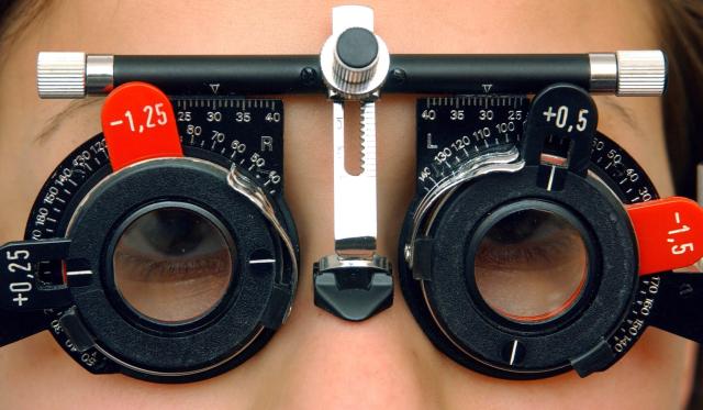 FILED - 01 April 2003, Brandenburg, Frankfurt_Oder: File Photo - A customer wears a pair of glasses which measures the eyesight in the local branch of Apollo Optik, the optician and eyeglasses corporation. Photo: Patrick Pleul/dpa