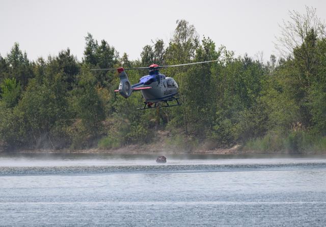 28 June 2026, Saxony, Zeithain: A police firefighting helicopter is on the scene of the wildfire in the Gohrischheide. A wildfire broke out there on Saturday afternoon. Photo: Robert Michael/dpa