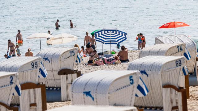 28 June 2026, Schleswig-Holstein, Timmendorfer Strand: People throng the sandy coastlines of the Baltic Sea to seek relief from a record-breaking heatwave. Photo: Markus Scholz/dpa