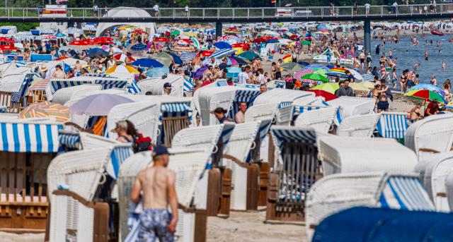 28 June 2026, Schleswig-Holstein, Timmendorfer Strand: People throng the sandy coastlines of the Baltic Sea to seek relief from a record-breaking heatwave. Photo: Markus Scholz/dpa