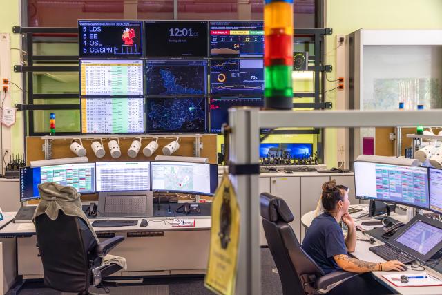28 June 2026, Brandenburg, Cottbus: An employee at the Lausitz Control Center sits in the operations center in front of computer monitors displaying current operations. Monitors showing overviews hang on the wall. Currently, there is an increased need for rescue operations due to heat-related illnesses. Temperatures in the region are expected to reach around 40 degrees Celsius again today, Sunday. Photo: Frank Hammerschmidt/dpa