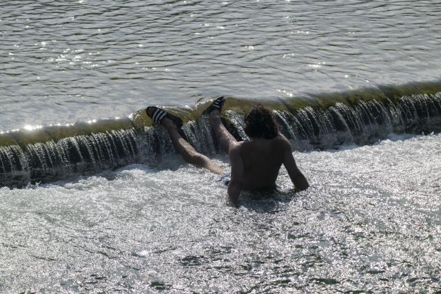 28 June 2026, Bavaria, Munich: A man is enjoying a refreshing dip in the waters of the Isar in the heart of the Bavarian capital. Photo: Peter Kneffel/dpa