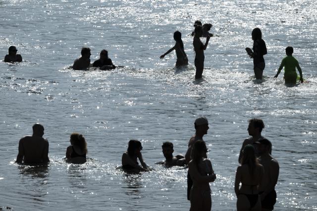 28 June 2026, Bavaria, Munich: People cool off at the Isar in the heart of the Bavarian capital. Photo: Peter Kneffel/dpa