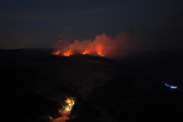 28 June 2026, Rhineland-Palatinate, Traisen: Flames are blazing in the forest on the Schanzenkopf in a nature reserve in the Bad Kreuznach district. The forest fire, which continues to spread in this area contaminated with unexploded ordnance, has led to the evacuation of the entire municipality of Traisen. Photo: Kevin Schößler/dpa