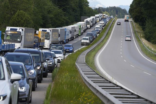 29 June 2026, Bavaria, Übersee: Traffic is backed up on the A8 highway near Lake Chiemsee due to a complete closure, as a forest and a marsh near the highway are on fire. A police spokesperson said the rising smoke is causing reduced visibility. The fire department is also warning the public and asking people to keep their windows and doors closed. Photo: Uwe Lein/dpa