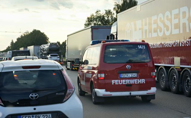 29 June 2026, Bavaria, Übersee: A fire truck is using the emergency lane in a traffic jam on the A8 highway near Lake Chiemsee during a complete road closure, as a forest and marshland near the highway are on fire. The rising smoke is causing reduced visibility, a police spokesperson said. The fire department is also warning the public and asking people to keep their windows and doors closed. Photo: Uwe Lein/dpa