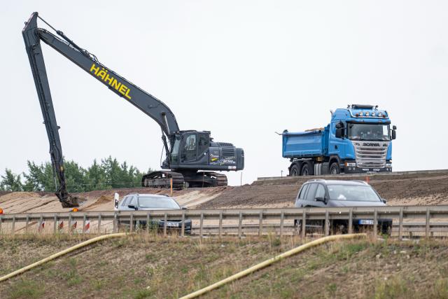 29 June 2026, Brandenburg, Wittenberge: An excavator is at work on the sidelines of the groundbreaking ceremony for the new Elbe Bridge. Photo: Fabian Sommer/dpa