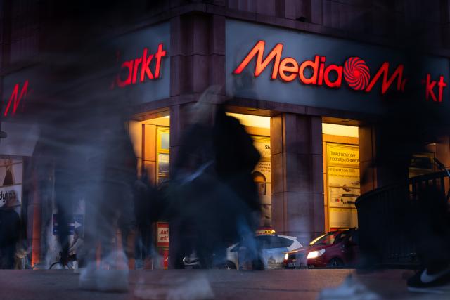 FILED - 08 December 2025, Berlin: FILE PHOTO - The Media Markt logo at Alexanderplatz is lit up as people walk by in front of it. Photo: Sebastian Gollnow/dpa