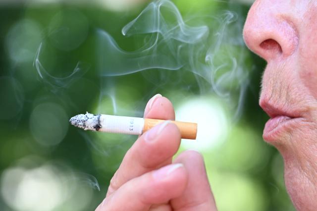 FILED - 27 May 2026, Baden-Württemberg, Stuttgart: FILE PHOTO - A smoker holds a lit cigarette and blows out smoke. Photo: Bernd Weißbrod/dpa