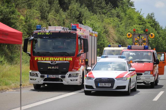 30 June 2026, North Rhine-Westphalia, Mechernich: Emergency vehicles are parked at the scene after a hazardous-materials truck overturned on Highway 1. Local police completely closed the heavily traveled transit route in both directions between the Mechernich and Nettersheim interchanges in the Euskirchen district following a hazardous materials accident involving spilled asbestos waste, triggering severe regional traffic disruptions. Photo: STR/dpa