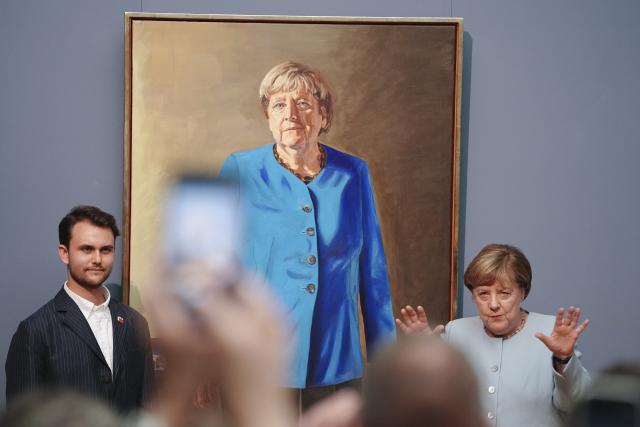 30 June 2026, Berlin: Angela Merkel (R), former German chancellor, and artist Jeremie Queyras (L) unveil the portrait of the former chancellor for the Hall of Fame at the German Chancellery. The portrait will be displayed at the Bode Museum until 4 October 2026 before being moved to the German Chancellery. Photo: Kay Nietfeld/dpa
