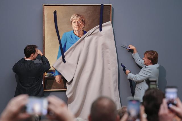 30 June 2026, Berlin: Angela Merkel (R), former German chancellor, and artist Jeremie Queyras (L) unveil the portrait of the former chancellor for the Hall of Fame at the German Chancellery. The portrait will be displayed at the Bode Museum until 4 October 2026 before being moved to the German Chancellery. Photo: Kay Nietfeld/dpa