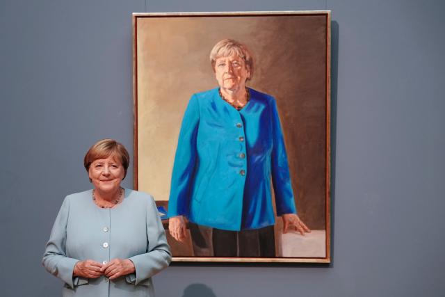 30 June 2026, Berlin: Angela Merkel, former Chancellor of Germany, stands in front of her portrait for the Hall of Ancestors at the German Chancellery. The painting will be displayed at the Bode Museum through 4 October 2026 before being moved to the Federal Chancellery. Photo: Kay Nietfeld/dpa