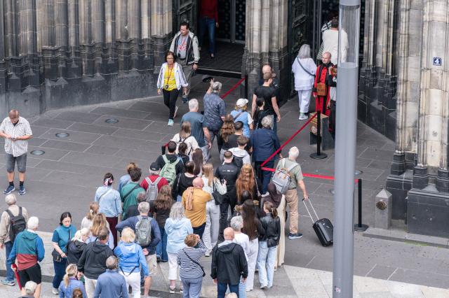 FILED - 02 June 2026, North Rhine-Westphalia, Cologne: Visitors stand outside Cologne Cathedral in Cologne. Photo: Benjamin Westhoff/dpa