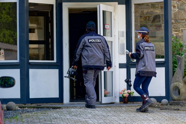 01 July 2026, North Rhine-Westphalia, Monschau: German Police enter a building, where several people have died in a fire in the Eifel region. Photo: Henning Kaiser/dpa