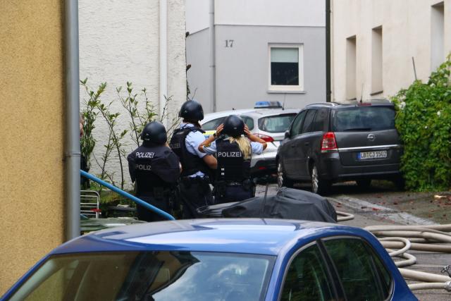 01 July 2026, Baden-Württemberg, Ingersheim: Police officers are on the scene of a fire at a residential building. Police describe the incident as a major operation involving the fire department and the police, with surrounding buildings being evacuated for safety reasons. Photo: Karsten Schmalz/KS-Images/dpa