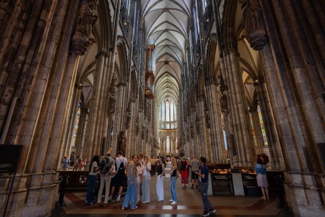 01 July 2026, North Rhine-Westphalia, Cologne: Tourists stand inside Cologne Cathedral. From 1 July, admission to the cathedral costs visitors 12 euros. Those wishing to pray continue to have free access to a designated area. Photo: Rolf Vennenbernd/dpa