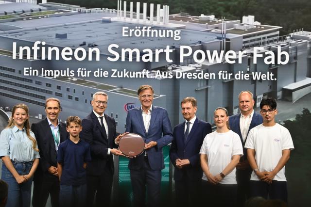 02 July 2026, Saxony, Dresden: CEO of Infineon Jochen Hanebeck, (C), German Minister for Digitalization and State Modernization Karsten Wildberger (4th L), Minister President of Saxony Michael Kretschmer (4th R), Mayor of Dresden Dirk Hilbert (2nd R), and Member of the Executive Board and Chief Operations Officer (COO) at Infineon Alexander Gorski (2nd L) stand alongside trainees at the opening of Semiconductor Plant of the Infineon Smart Power Fab. Photo: Robert Michael/dpa