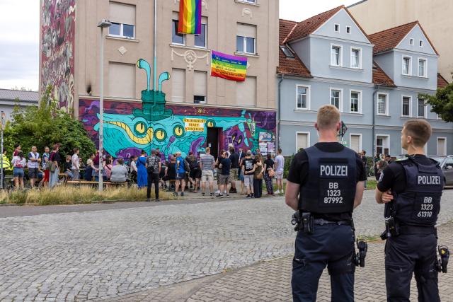 02 July 2026, Brandenburg, Cottbus: Police officers stand outside the alternative youth project "Zelle 79" in Cottbus during a vigil. An arson attack, believed to have been carried out by right-wing extremists, took place here last night. Photo: Frank Hammerschmidt/dpa