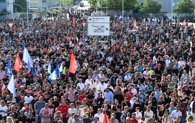 03 July 2026, Baden-Württemberg, Sindelfingen: Employees of the automaker Mercedes-Benz protest against the company's cost cutting measures, at one of the entrances to the Mercedes-Benz plant. Photo: Bernd Weißbrod/dpa