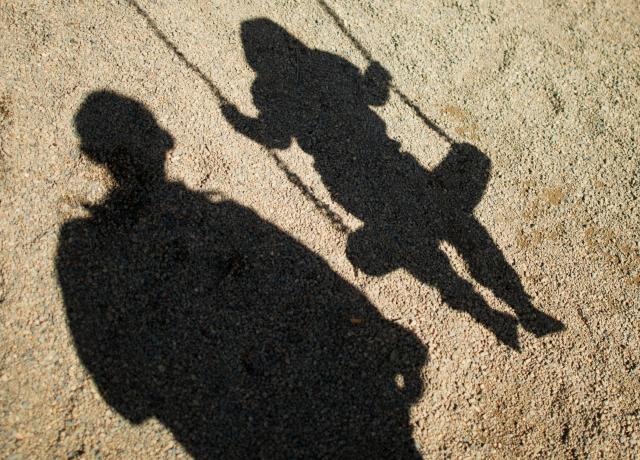 FILED - 27 August 2014, Lower Saxony, Braunschweig: FILE PHOTO - A view of the shadows of a man and a child on a swing in Braunschweig. Fewer children were adopted in Germany last year than at any time since German reunification in 1990, according to official data. Photo: Julian Stratenschulte/dpa