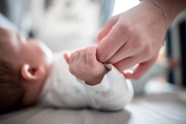 FILED - 30 December 2019, North Rhine-Westphalia, Oberhausen: FILE PHOTO - A baby clings to its mother's finger. Fewer children were adopted in Germany last year than at any time since German reunification in 1990, according to official data. Photo: Fabian Strauch/dpa