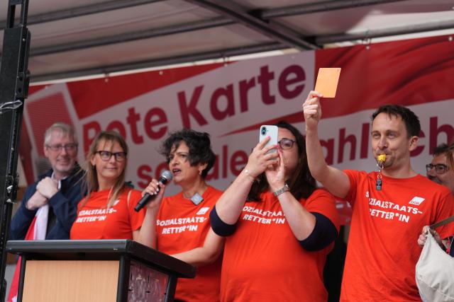 03 July 2026, Hamburg: DGB Hamburg chairwoman Tanja Chawla (C) speaks with ver.di Hamburg director Sandra Goldschmidt (2nd L) at a rally against social cuts. Organized by the DGB and Hamburg Tenants' Association under the slogan "No to Social Cuts-Defenders of the Welfare State Stand Together!", protesters demanded affordable housing, a nationwide rent freeze, and a stronger welfare state. Photo: Marcus Brandt/dpa