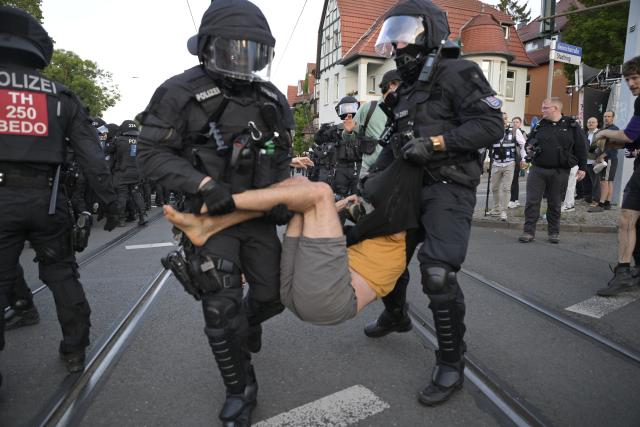 04 July 2026, Thuringia, Erfurt: Police officers remove a protester during a demonstration against the national party convention of the Alternative for Germany (AfD) pary. The AfD's national party convention is taking place on July 4 and 5 at the Erfurt Convention Center. Photo: Jacob Schröter/dpa