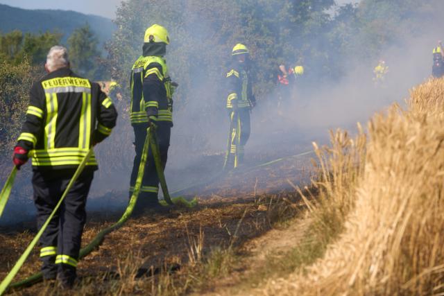 04 July 2026, Rhineland-Palatinate, Bad Neuenahr: Firefighters battle a wildfire in a grain field near the A61 highway in Bad Neuenahr. The hot and dry weather is increasing the risk of fire. Photo: Thomas Frey/dpa