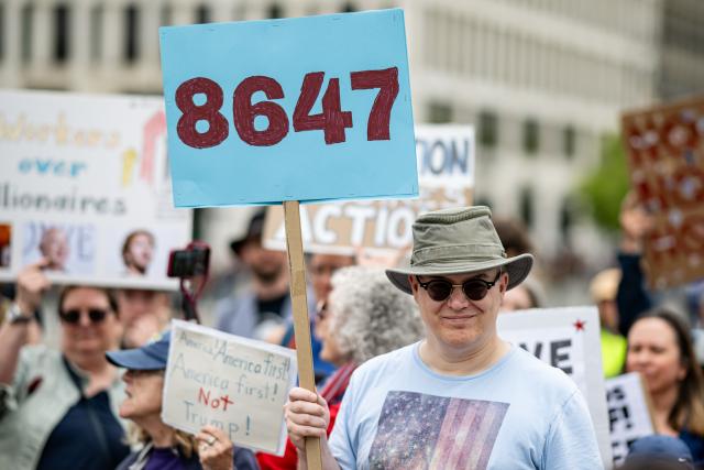 04 July 2026, Berlin: People take part in a rally organized by Democrats Abroad under the slogan "Defend Democracy - Fight Fascism" to mark the US Independence Day and the 250th anniversary of the founding of the US, holding a sign that reads "8647." "8647" is a political protest code well-known in the US that is used as a coded message, meaning "getting rid of" the US president. The 86 stands for getting rid of the 47th US president. Photo: Fabian Sommer/dpa