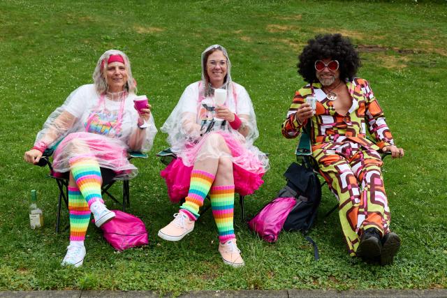 04 July 2026, Hamburg: Participants in the 2026 Schlagermove parade sit on Helgolaender Allee with rain capes. Photo: Georg Wendt/dpa