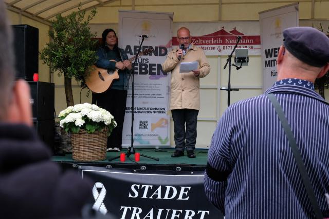04 July 2026, Lower Saxony, Stade: Mayoral candidate for Stade Kai Koeser (C) speaks on stage during a memorial service for the victims of last Monday's tragic homicide at a youth welfare facility. Photo: Carsten Neff/dpa